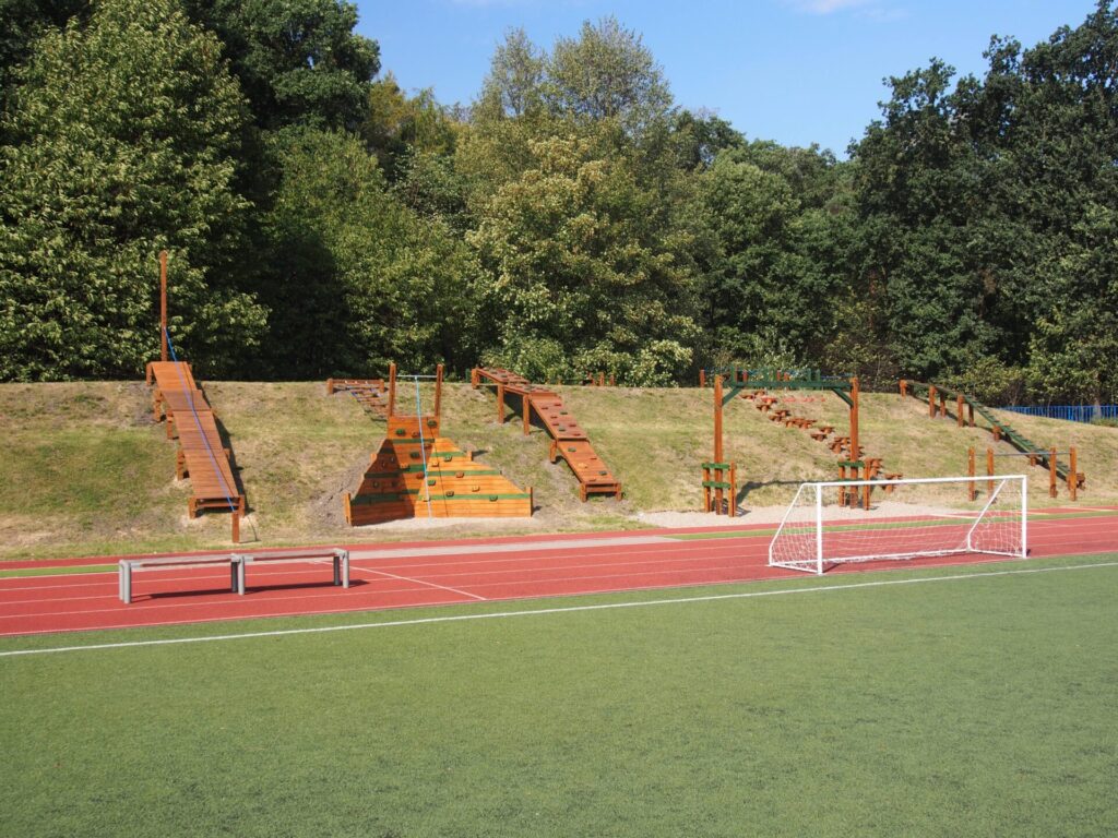 Workoutové Hřiště hrou umně využívající terénu za atletickým oválem